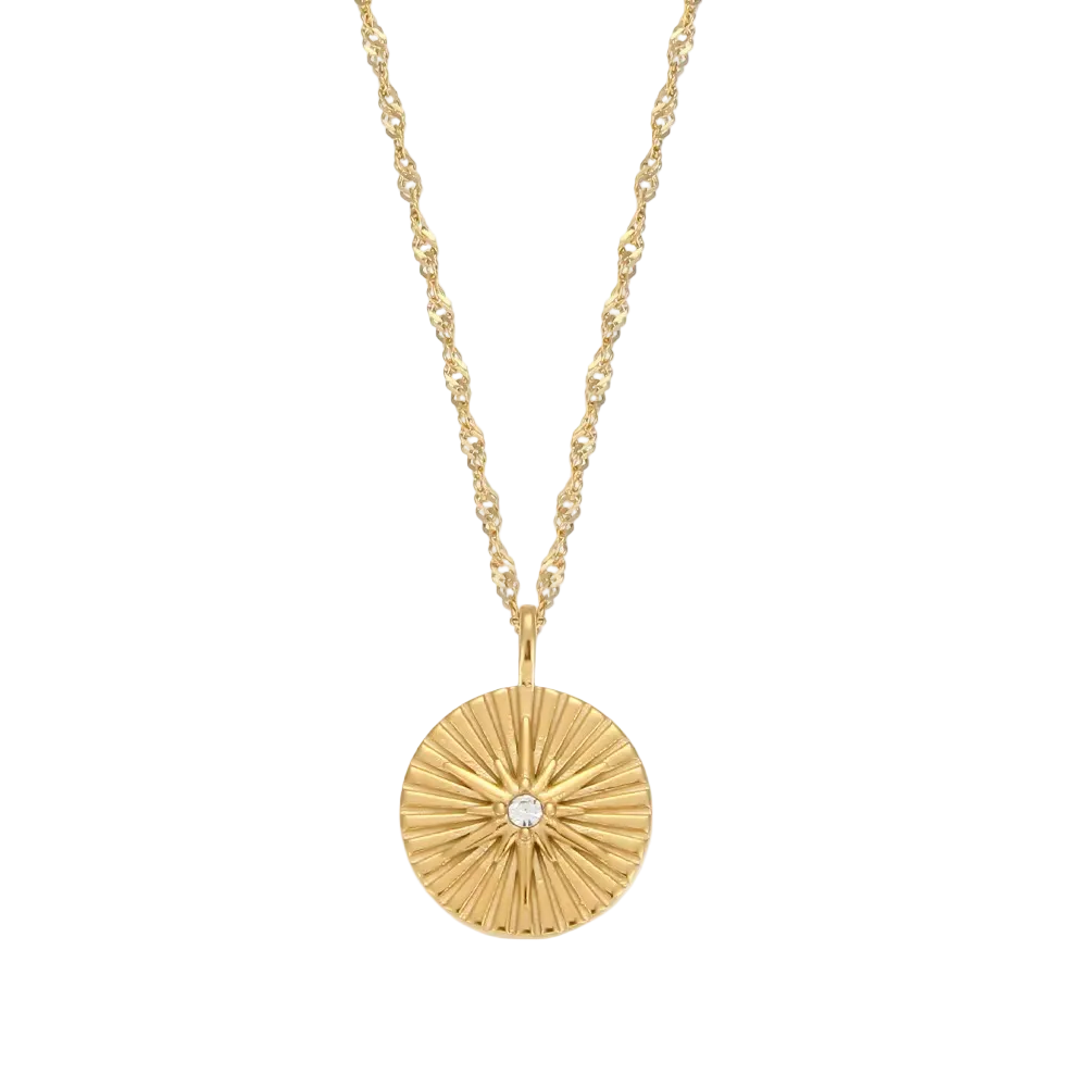 A gold chain necklace with a round, sunburst-textured gold pendant featuring a small clear central gemstone, shown against a plain white background.